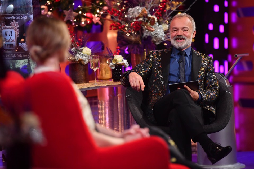 a man sits in front of a sign that says wild christmas thing