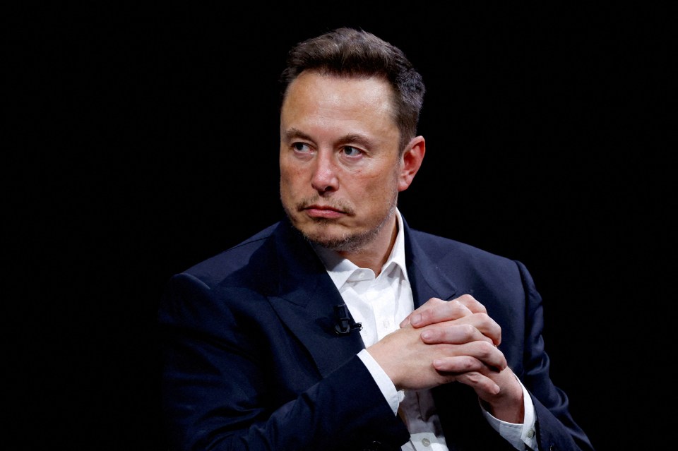a man in a suit has his hands folded in front of his face