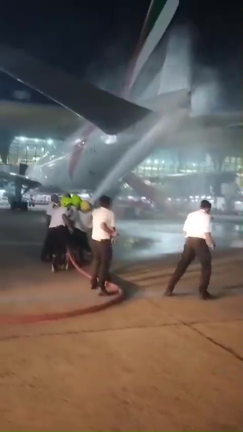 a group of people are spraying water on an airplane .