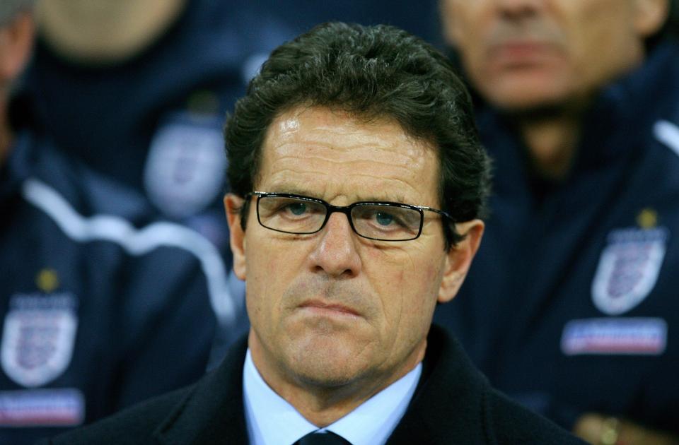 a man wearing glasses and a suit looks at the camera