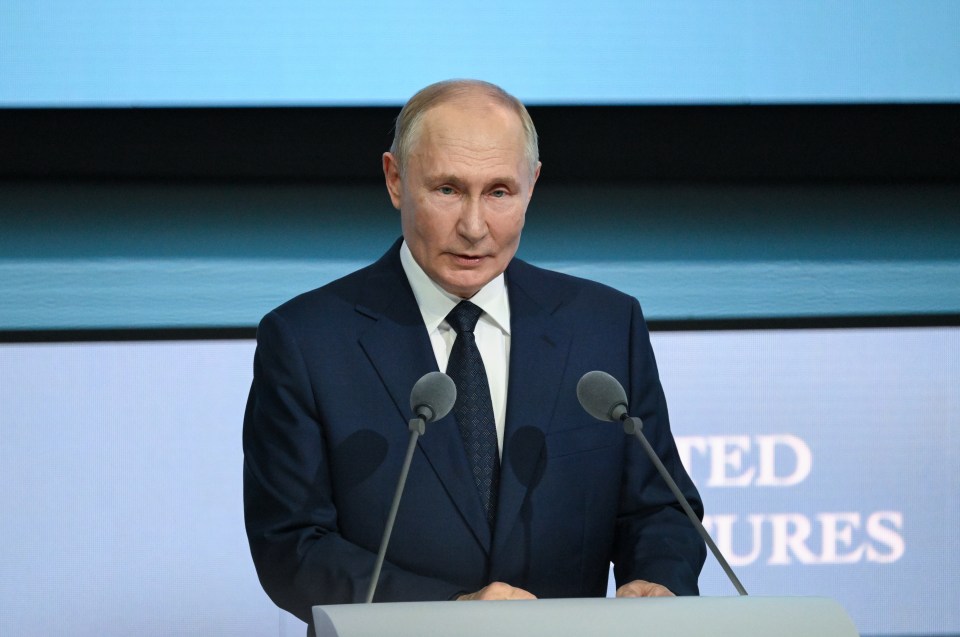 a man in a suit and tie stands at a podium in front of a screen that says united ures