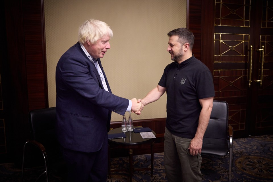 two men shaking hands with one wearing a black shirt