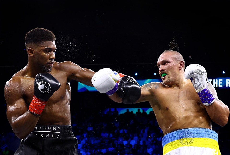 two boxers are fighting and one has the word shua on his shorts