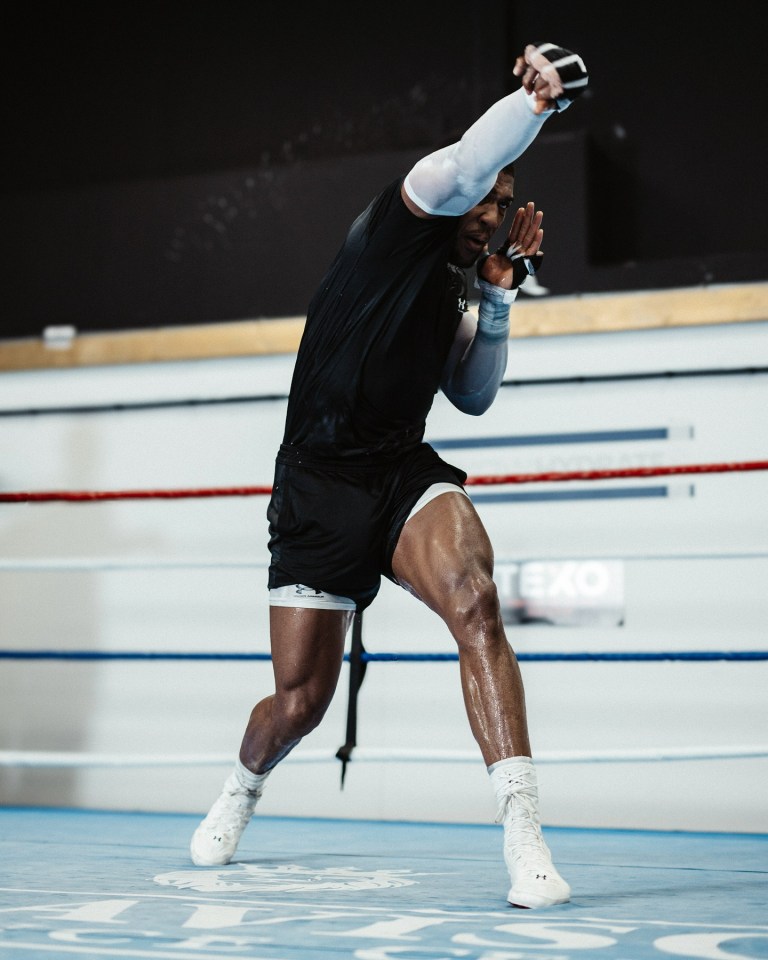 a man in a black shirt and white socks is in a boxing ring