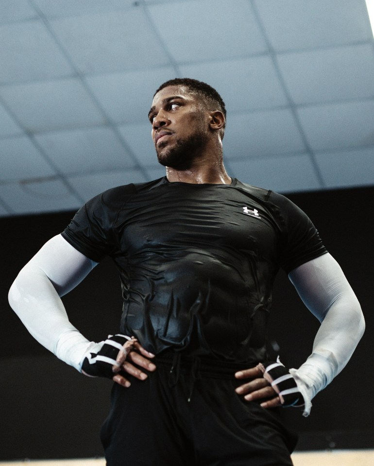 a man wearing a black under armour shirt stands with his hands on his hips