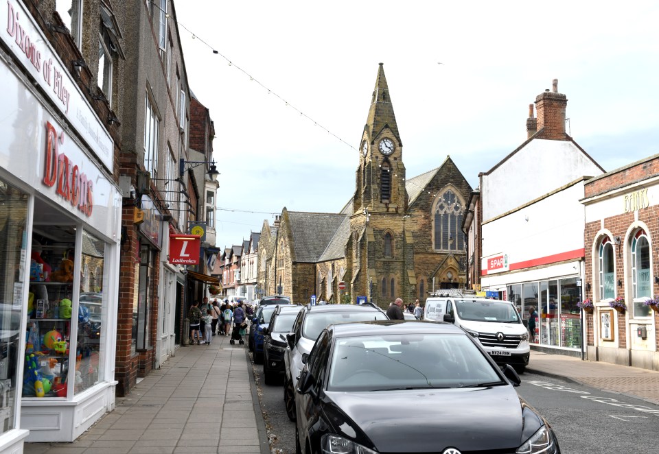 a busy street with a clock tower in the background