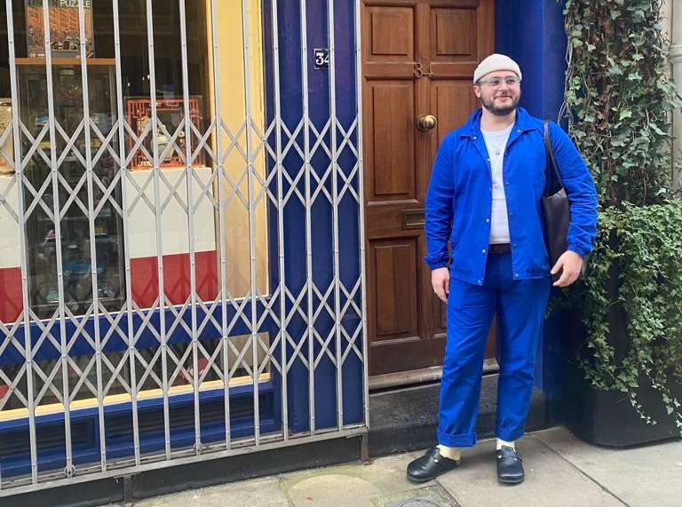a man standing in front of a store with the number 3 on the door