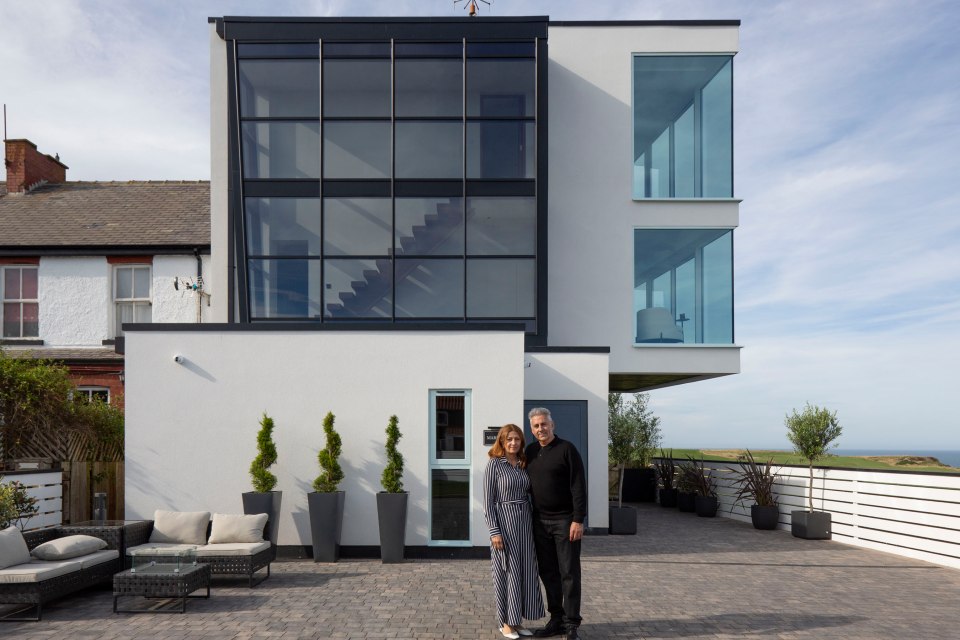 a man and woman standing in front of a white building