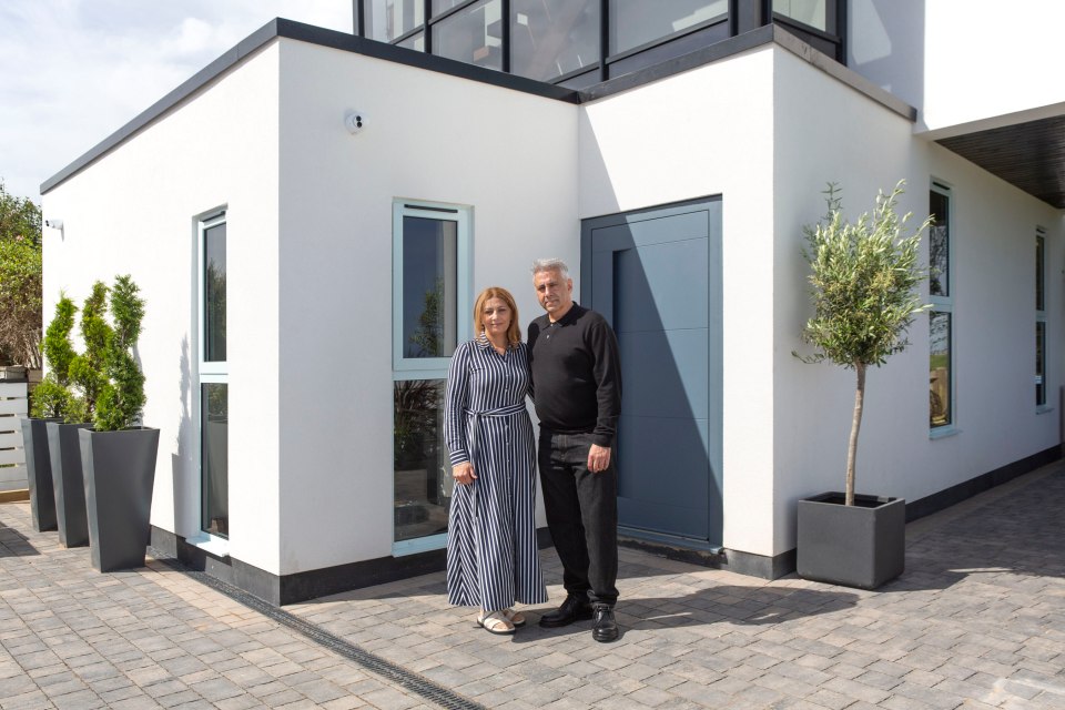 a man and woman standing in front of a white building
