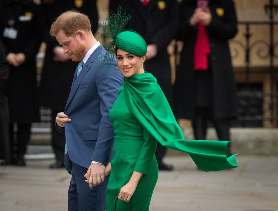 a man in a suit and a woman in a green dress are holding hands