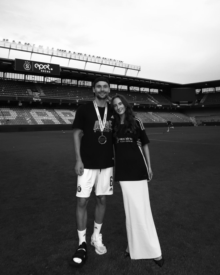 a black and white photo of a man and a woman in front of a stadium that says epct
