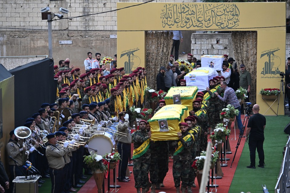 a group of soldiers are carrying a coffin with a picture of a man on it