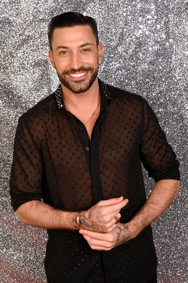 a man with a beard wears a black shirt with polka dots