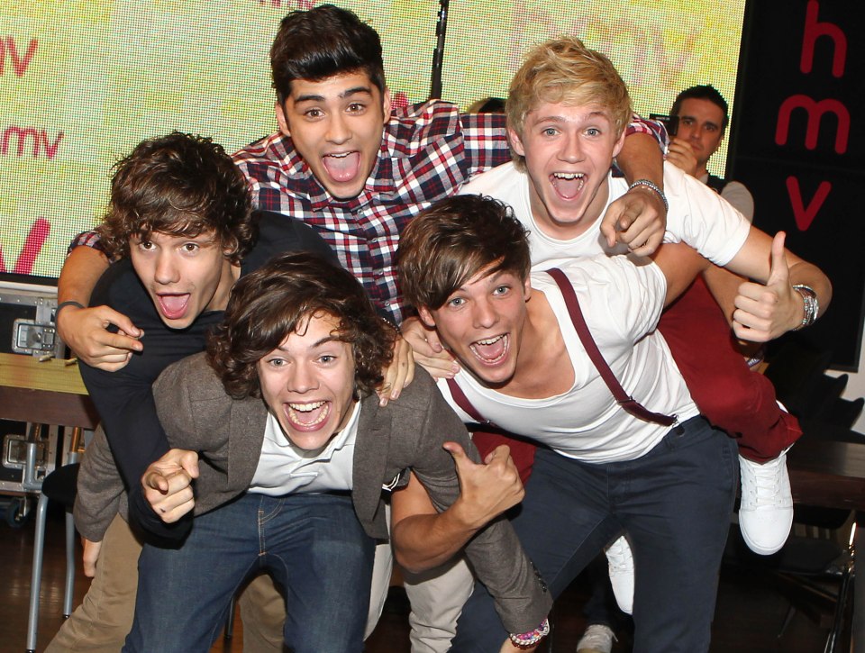 a group of young men are posing for a picture and one of them is giving a thumbs up