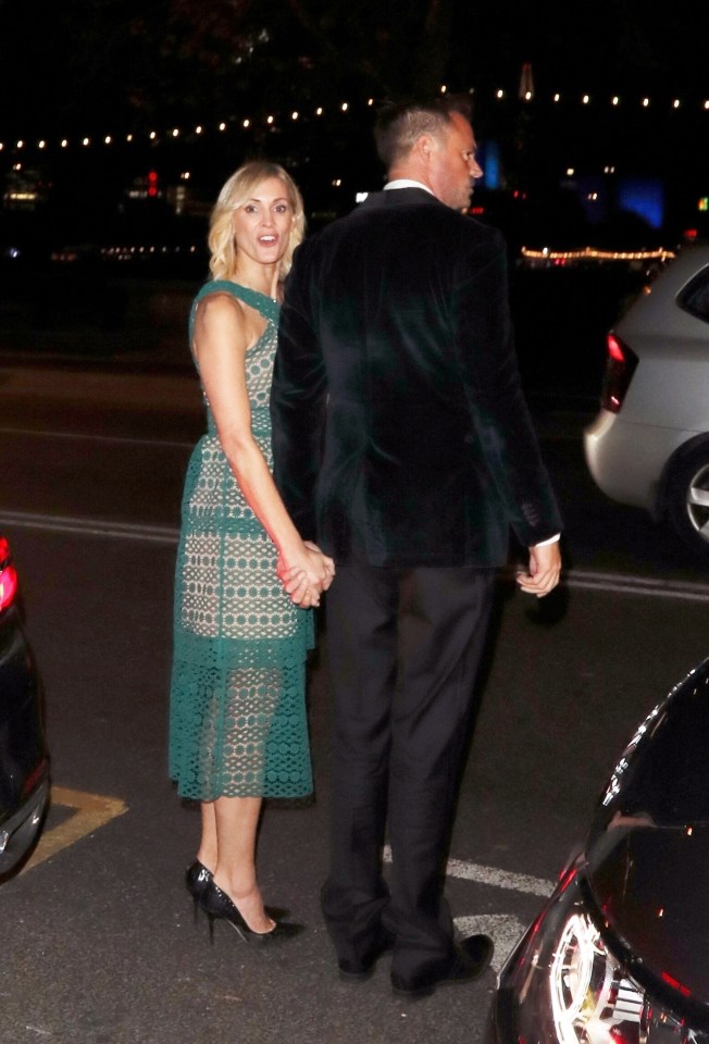 a woman in a green dress holds hands with a man in a black suit