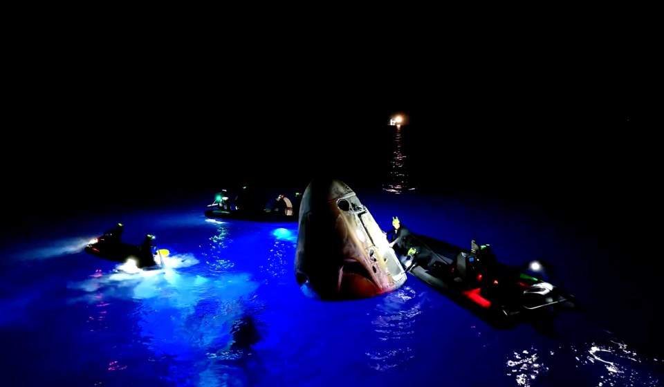 a group of boats are in the water at night