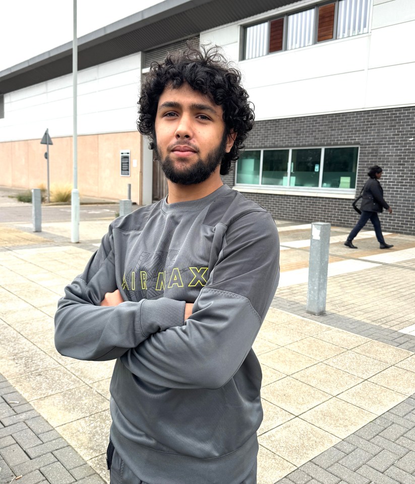 a man wearing an air max sweatshirt stands with his arms crossed