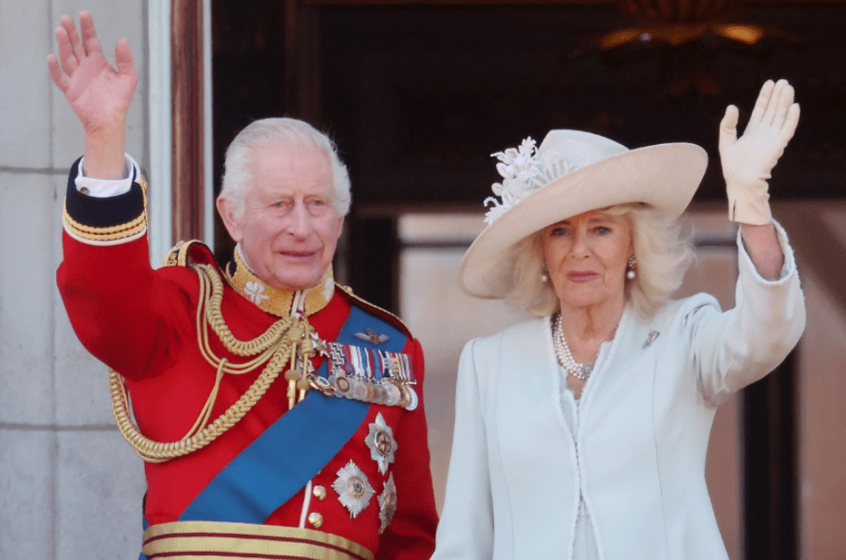 a man in a red uniform and a woman in a white hat are waving