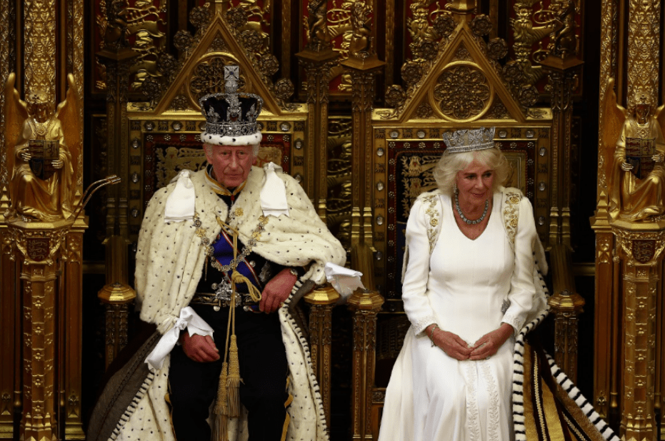 a man in a crown stands next to a woman in a white dress