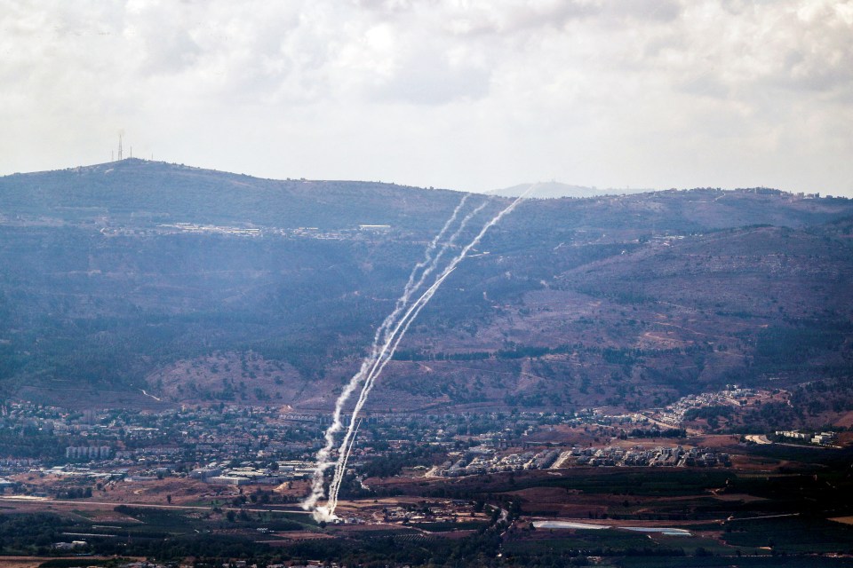 an aerial view of a valley with mountains in the background