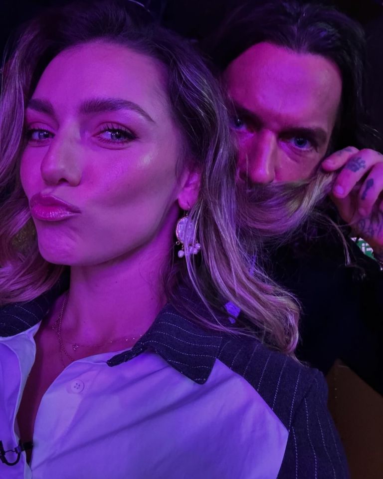 a man with a tattoo on his finger is holding a woman 's hair in front of his face