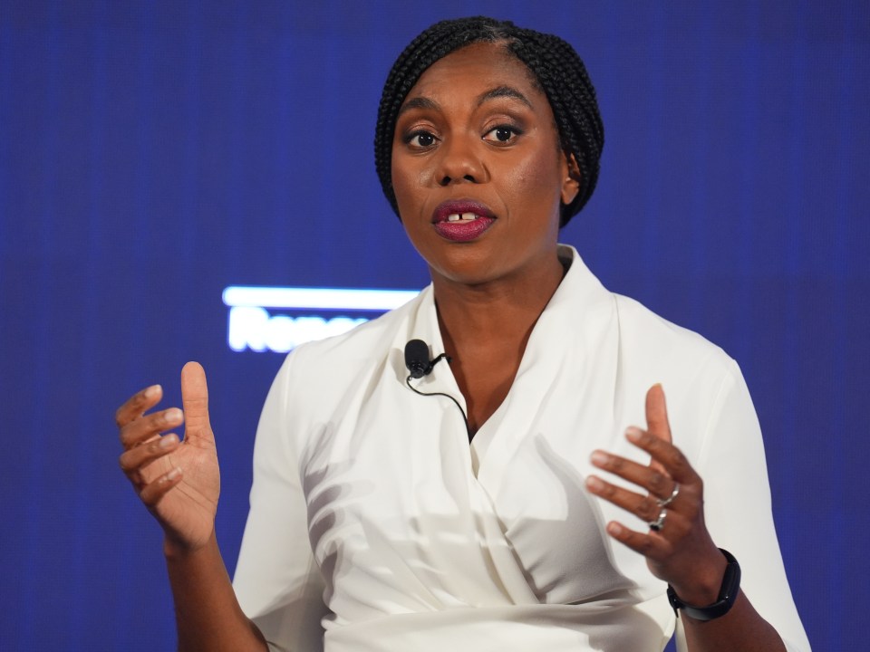 a woman in a white shirt is speaking into a microphone