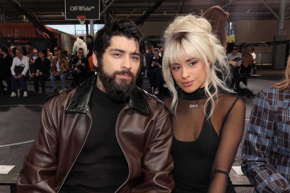 a man and a woman sit in front of a sign that says off white