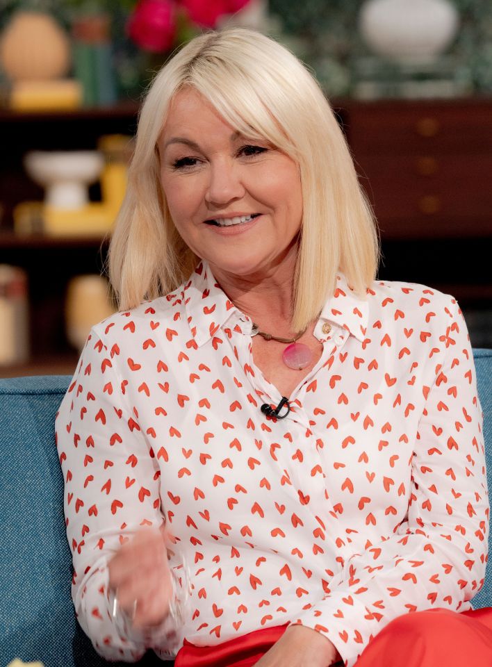a woman wearing a white shirt with red hearts on it