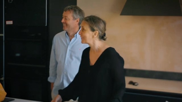a man and a woman are standing next to each other in a kitchen .