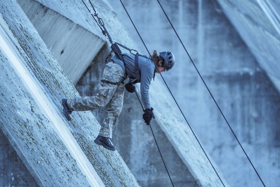 a person in a military uniform is climbing a concrete wall