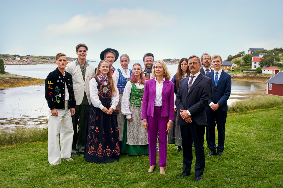 a group of people posing for a picture with one woman wearing a purple suit
