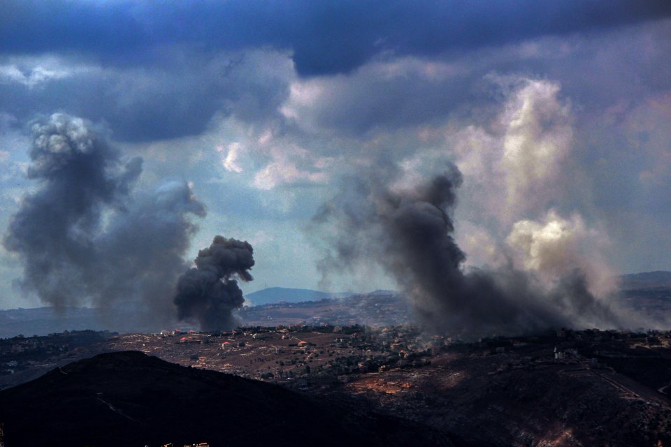 a cloudy sky with smoke coming out of the ground