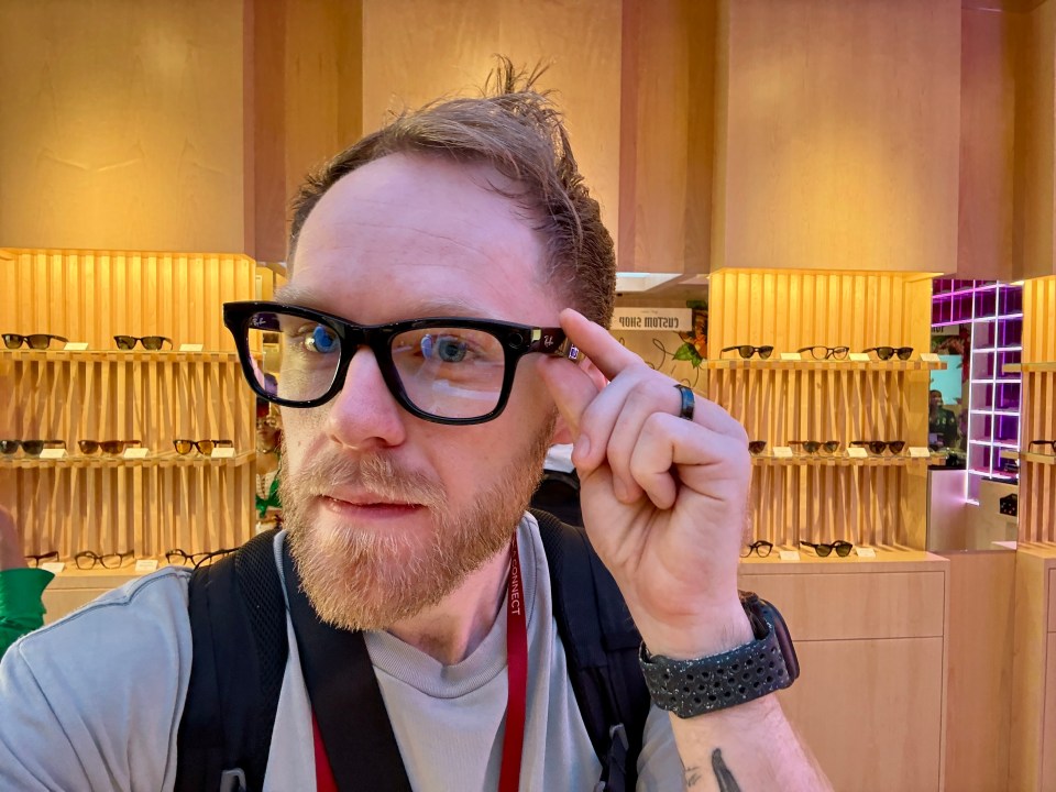 a man wearing glasses and a lanyard that says ' nikon ' on it