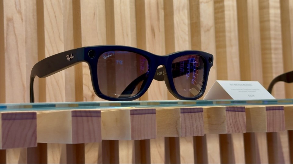 a pair of ray-ban sunglasses are displayed on a wooden shelf