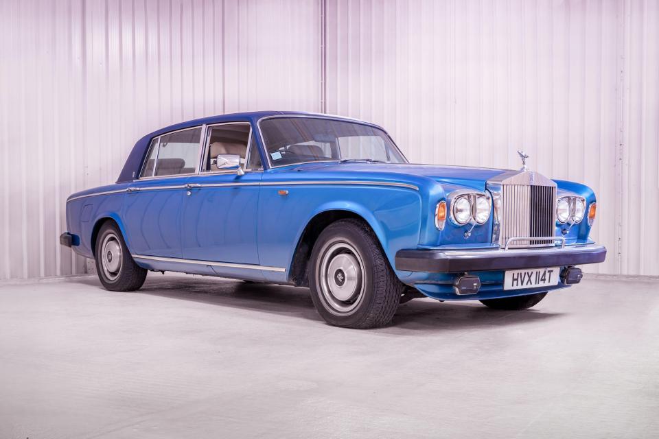 a blue rolls royce is parked in a garage