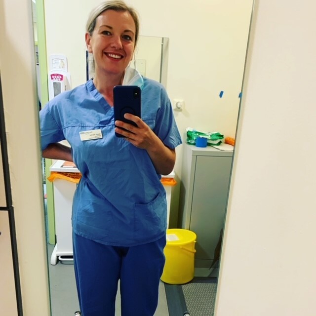 a nurse taking a picture of herself in front of a mirror
