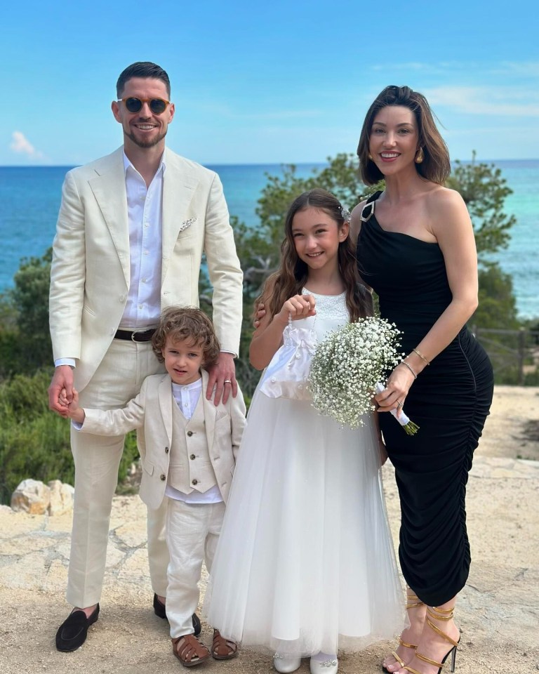 a family posing for a picture in front of the ocean