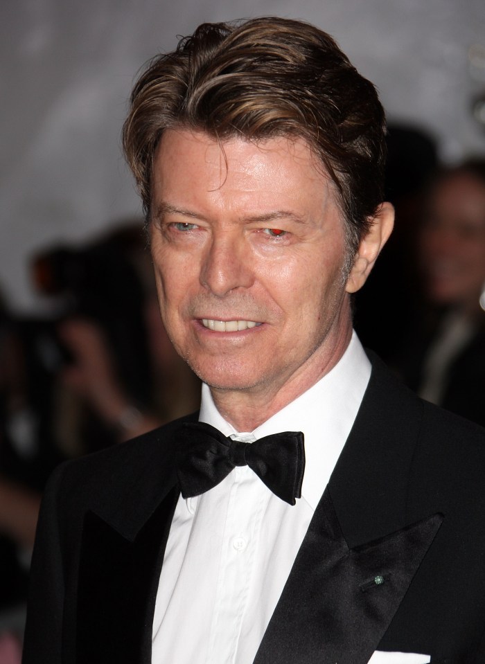 a man in a tuxedo and bow tie smiles for the camera