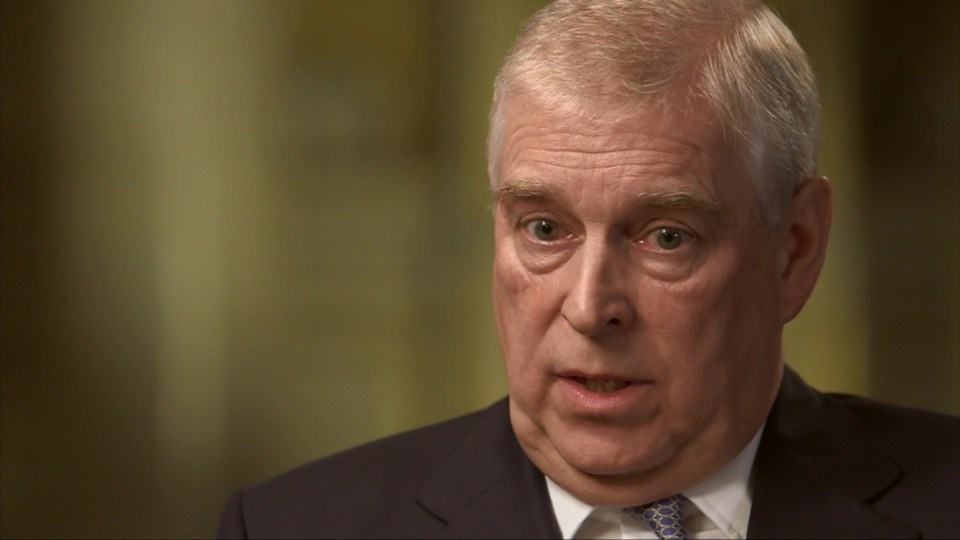 a man in a suit and tie looks at the camera