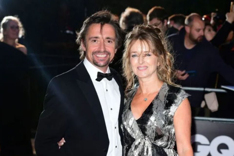 a man and a woman are posing for a picture on a red carpet