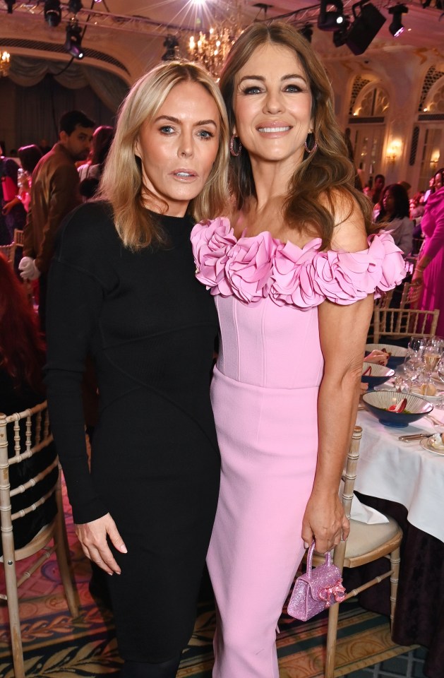 a woman in a pink dress stands next to another woman in a black dress