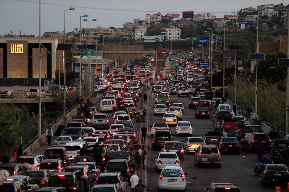 a lot of cars are driving down a highway at night