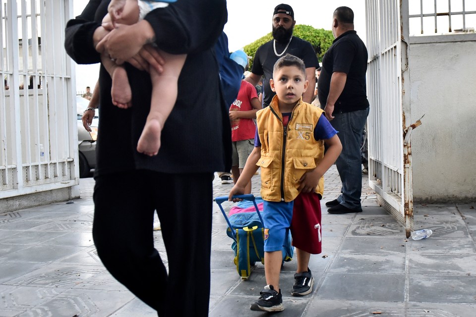 a boy wearing a yellow vest with the number 5 on it