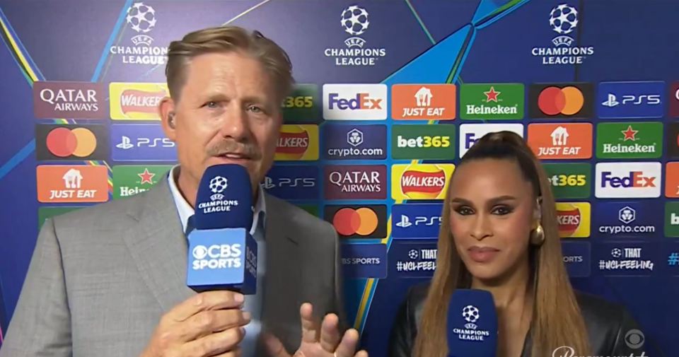 a man and a woman standing in front of a champions league backdrop