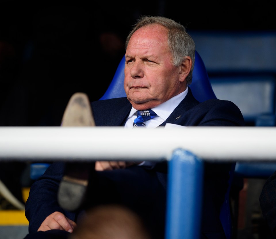 a man in a suit and tie sits in a blue chair