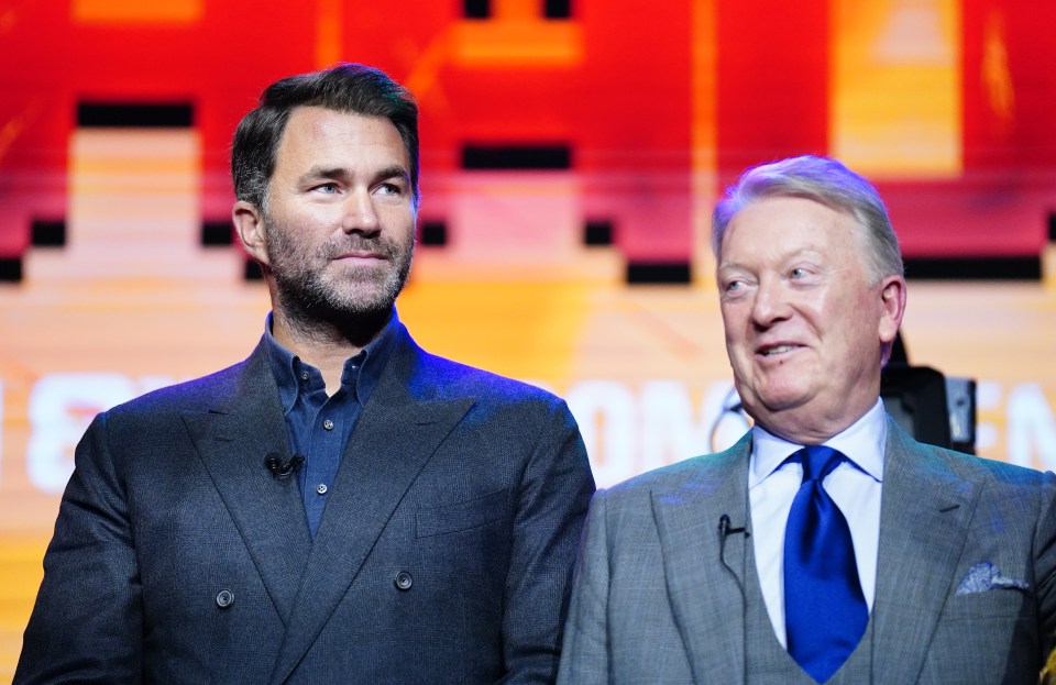 two men stand next to each other in front of a screen that says e on it