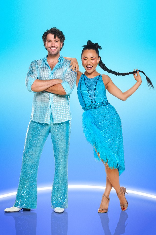 a man and a woman are posing for a picture in front of a blue background