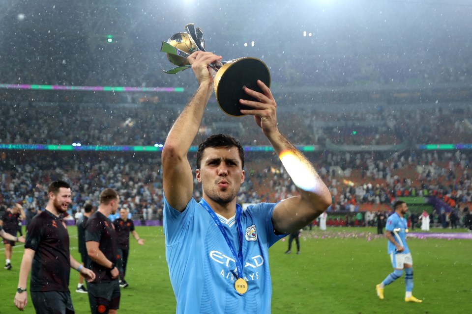 a man in an etihad jersey holds up a trophy