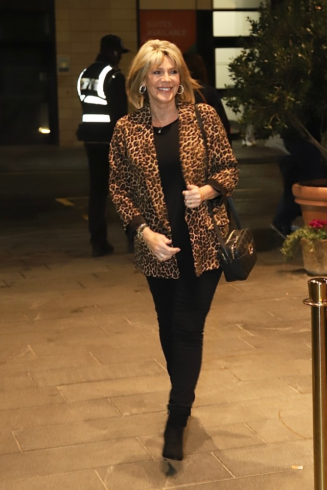 a woman wearing a leopard print jacket and black pants