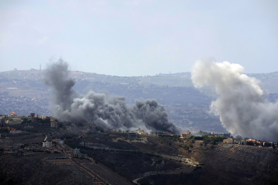 smoke is coming out of a building on a hillside